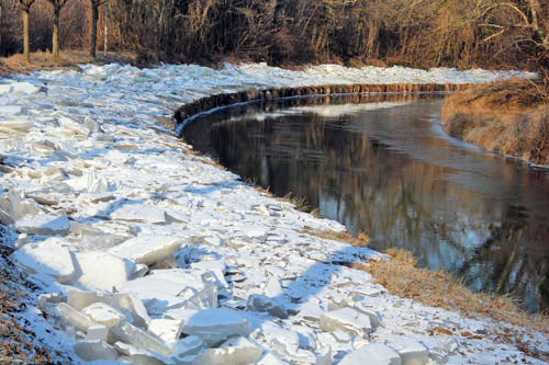 La glace enlevée du canal est déposée sur le chemin de halage